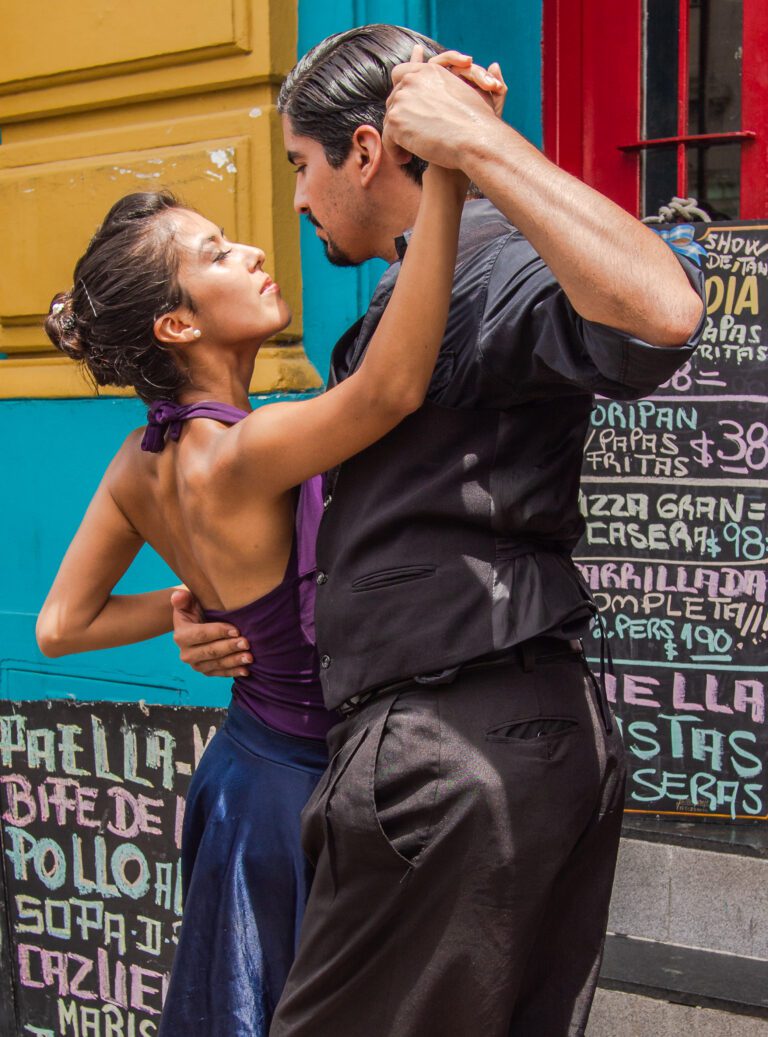 Buenos Aires, Argentina February, 01 2014: Attractive couple dancing passionate Latin dance near elderly male playing guitar on city street